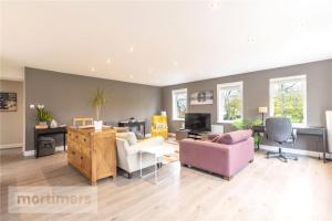 a living room with a couch and chairs and a tv at Spacious 2 Bed Ribble Valley Apartments in Blackburn