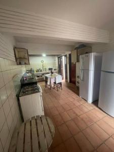a kitchen with a white refrigerator and a table at Casa Vila lagoinha in Lagoinha