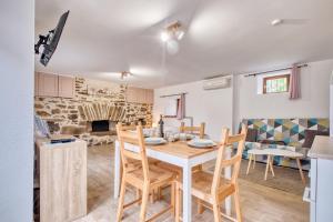 a kitchen and living room with a table and chairs at Les gîtes du Gauliat in Espartignac