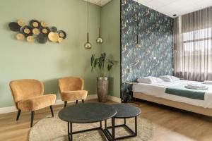 ein Zimmer mit einem Bett, zwei Stühlen und einem Tisch in der Unterkunft Hotel Ameland in Nes + 94 Fotos
