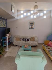 a living room with a couch and a chandelier at casa azul in Plottier