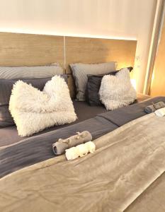 a large bed with pillows and stuffed animals on it at All Seasons Apartment in Durrës