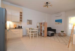 a kitchen and a living room with a table at All Seasons Apartment in Durrës