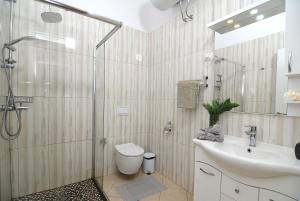a bathroom with a shower and a toilet and a sink at All Seasons Apartment in Durrës +61 photos