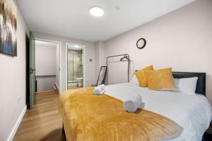 a bedroom with a large bed with yellow pillows at 2BR Apartment in Cardiff’s Vibrant Roath in Cardiff