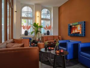 a living room with blue chairs and a table at Classik Hotel Antonius Köln City in Cologne