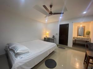 a bedroom with a bed and a ceiling fan at Nagaon Homestay in Nowgong