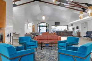 a living room with blue chairs and a couch at Desert Rose Resort in Las Vegas