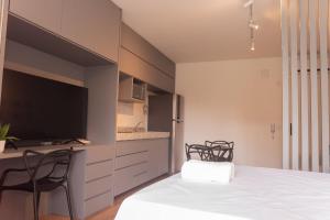 a kitchen with a table and two chairs and a television at Flat 400m da UFV 650m da Rodoviária in Viçosa