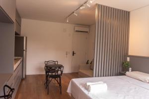 a bedroom with a bed and a table and chairs at Flat 400m da UFV 650m da Rodoviária in Viçosa
