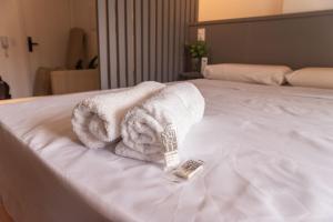 a pile of towels sitting on top of a bed at Flat 400m da UFV 650m da Rodoviária in Viçosa +30 photos