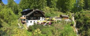 a building on a hill with umbrellas at Hupfmühle Pension in St. Wolfgang
