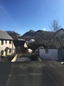 an empty street in a town with houses and mountains at Snowdon View in Llanberis