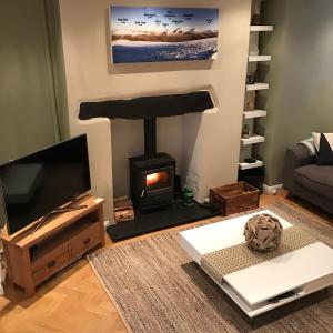 a living room with a fireplace and a television at Snowdon View in Llanberis