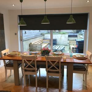 a dining room table with chairs and a kitchen at Snowdon View in Llanberis +16 photos