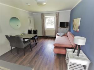ein Wohnzimmer mit einem rosa Sofa und einem Tisch in der Unterkunft 06 Grashüpfer - Hof Wiesengrund in Parchtitz
