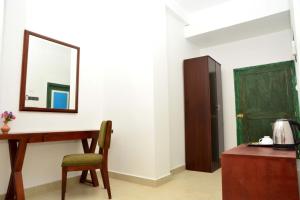 a room with a desk and a mirror and a chair at Ayurvedic Beach Resort in Negombo