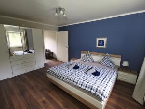 ein Schlafzimmer mit einem Bett und einer blauen Wand in der Unterkunft 06 Grashüpfer - Hof Wiesengrund in Parchtitz + 23 Fotos