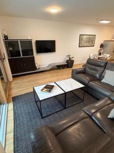 a living room with a leather couch and a coffee table at Skyline-View in Gerasdorf bei Wien