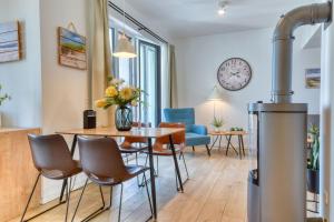 a living room with a table and chairs and a clock at Ferienwohnung SPA Penthouse Meerlust Baabe in Baabe