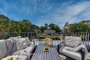 a patio with two couches and a table and chairs at Ferienwohnung SPA Penthouse Meerlust Baabe in Baabe +2 photos