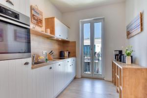a kitchen with white cabinets and a large window at Ferienwohnung SPA Penthouse Meerlust Baabe in Baabe