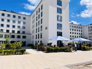 a building with tables and umbrellas in front of it at Ferienwohnung Aquamarin im Haus Arkona Prora in Binz