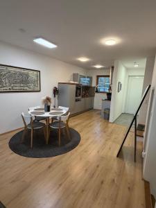 a living room with a table and chairs and a kitchen at Skyline-View in Gerasdorf bei Wien