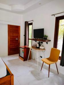 a bedroom with a desk and a tv and a chair at Sweet Room by Maliblue Khanom in Ban Phang Phrao