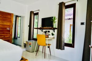 a bedroom with a table and a yellow chair at Sweet Room by Maliblue Khanom in Ban Phang Phrao