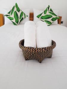 a basket filled with towels sitting on top of a bed at Sweet Room by Maliblue Khanom in Ban Phang Phrao
