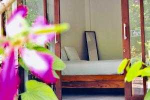 a room with a bed with a mirror and flowers at Sweet Room by Maliblue Khanom in Ban Phang Phrao +3 photos