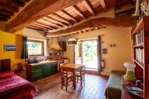 a kitchen with a bed and a table in a room at Romantic stone farmhouse studios with private terrace in beautiful Tuscany in Subbiano