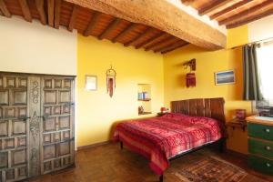 a bedroom with a red bed and yellow walls at Romantic stone farmhouse studios with private terrace in beautiful Tuscany in Subbiano