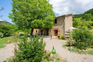 a stone house with two green vases in front of it at Romantic stone farmhouse studios with private terrace in beautiful Tuscany in Subbiano