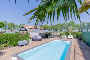 a swimming pool in the backyard of a house at B&B Plompetorenzicht in Burgh Haamstede