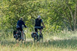 two people riding bikes in a field at B&B Plompetorenzicht in Burgh Haamstede