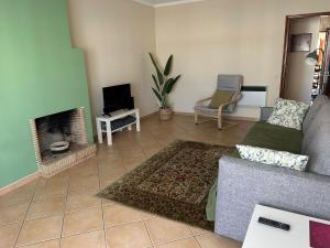 a living room with a couch and a fireplace at cosy2bedroomapartment in Loulé