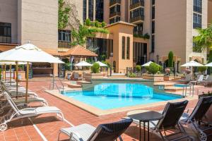 a swimming pool with chairs and tables and umbrellas at Hotel Saray in Granada