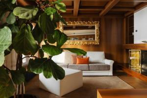 a living room with a couch and a plant at Gran Tubla Apartments Dolomites in Ortisei +22 photos