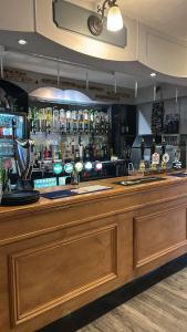a bar with a large wooden counter with alcohol bottles at Withamside Country Park in Boston +5 photos