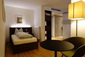 a bedroom with a bed and a table and a room at Jägermayrhof in Linz +48 photos