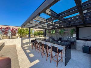 a patio with a bar with chairs and a tv at Skylux By Cris Borriello Luxury in Rio de Janeiro