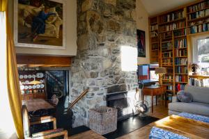 a living room with a stone fireplace and a couch at Ty Uchaf in Colwyn Bay