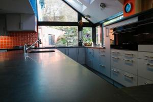a kitchen with white cabinets and a large window at Ty Uchaf in Colwyn Bay
