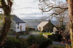 an old cottage and a house on a hill at Ty Uchaf in Colwyn Bay
