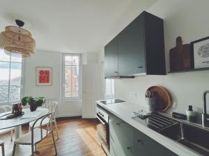 a kitchen with a counter and a table with chairs at Suite Jaurès in Rethel