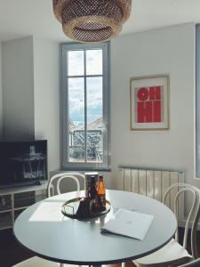 a white table and chairs in a room with a window at Suite Jaurès in Rethel +2 photos