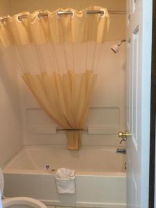 a bathroom with a toilet and a tub with a curtain at Americas Best Value Inn Cabot in Cabot
