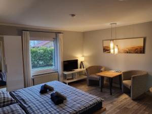 a room with two beds and a table and a television at 02 Kornblume - Hof Wiesengrund in Parchtitz